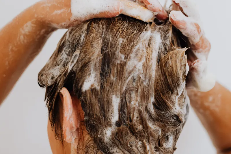 Person massaging shampoo into their scalp