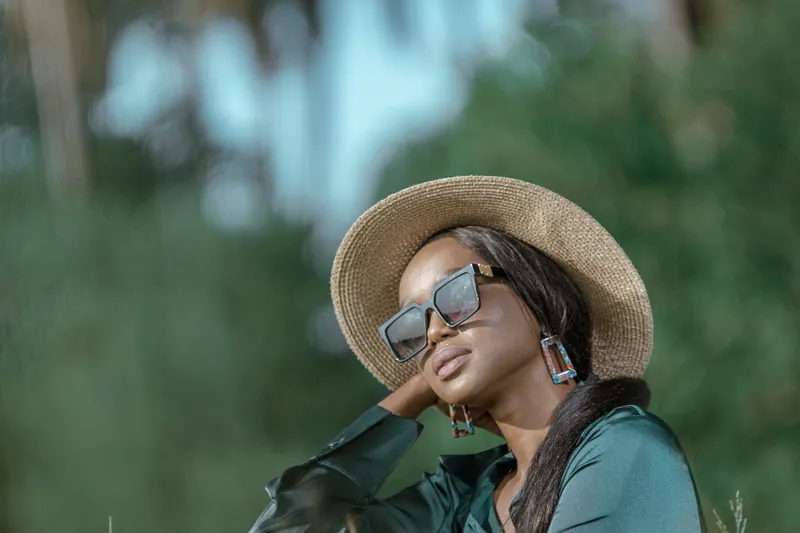 Woman wearing a wide-brimmed hat and sunglasses outdoors
